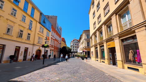 bratislava, slovakia, 2 june 2025: paved road surrounded by beautiful old buildings. sunny view of the cozy street in bratislava, slovakia