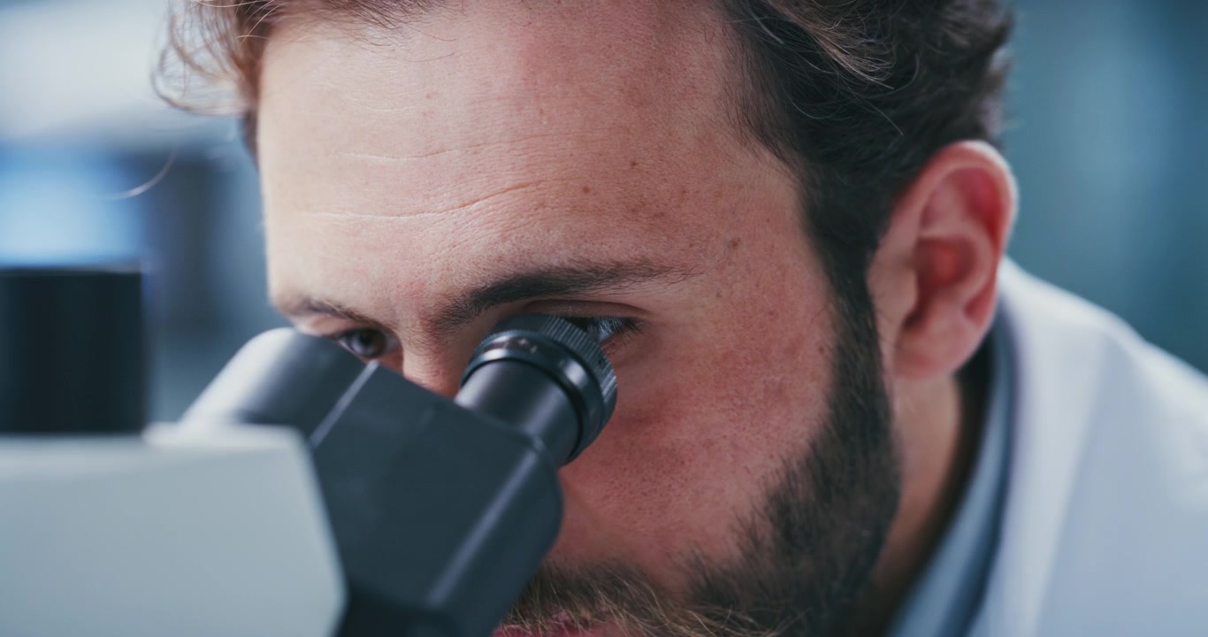 Uno scienziato che guarda attraverso un microscopio in un laboratorio