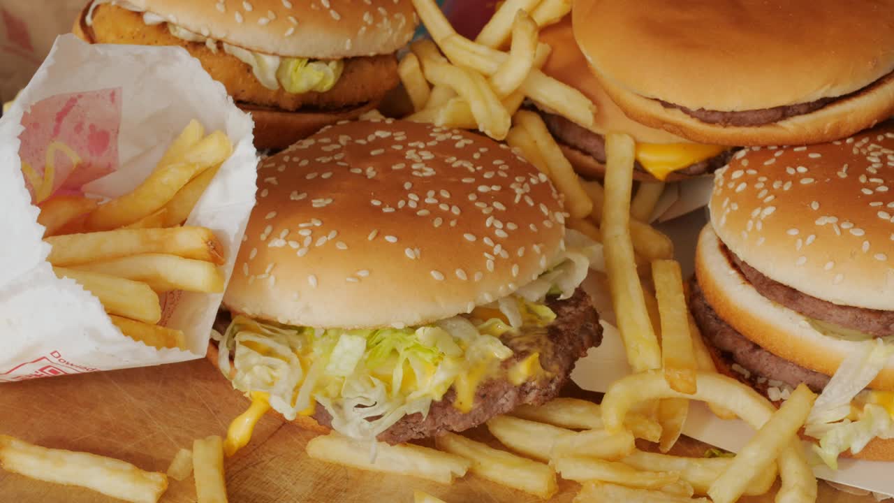 porción de comida no saludable, comida rápida, pila de hamburguesas, patatas fritas girando, girando