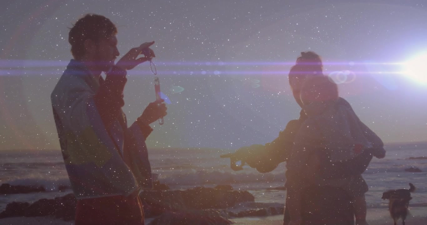 Man dipping bubble wand, forming drifting bubble delighting infant as woman guides for health