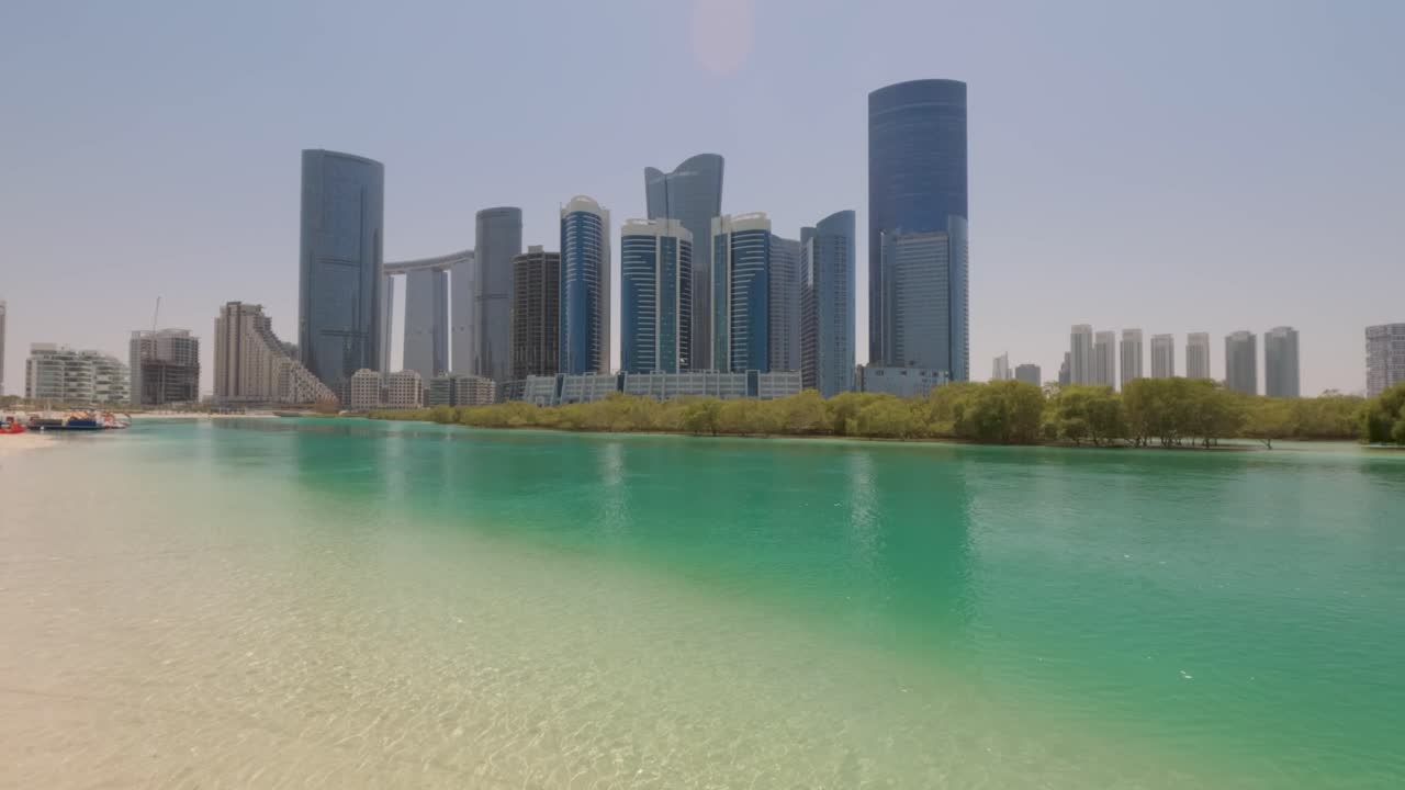 Scenic view of Abu Dhabi's Al Reem Island's city skyline from the beach on a sunny day in the United Arab Emirates