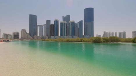 scenic view of abu dhabi's al reem island's city skyline from the beach on a sunny day in the united arab emirates