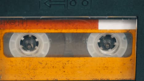 the vintage yellow audio cassette in the tape recorder rotates