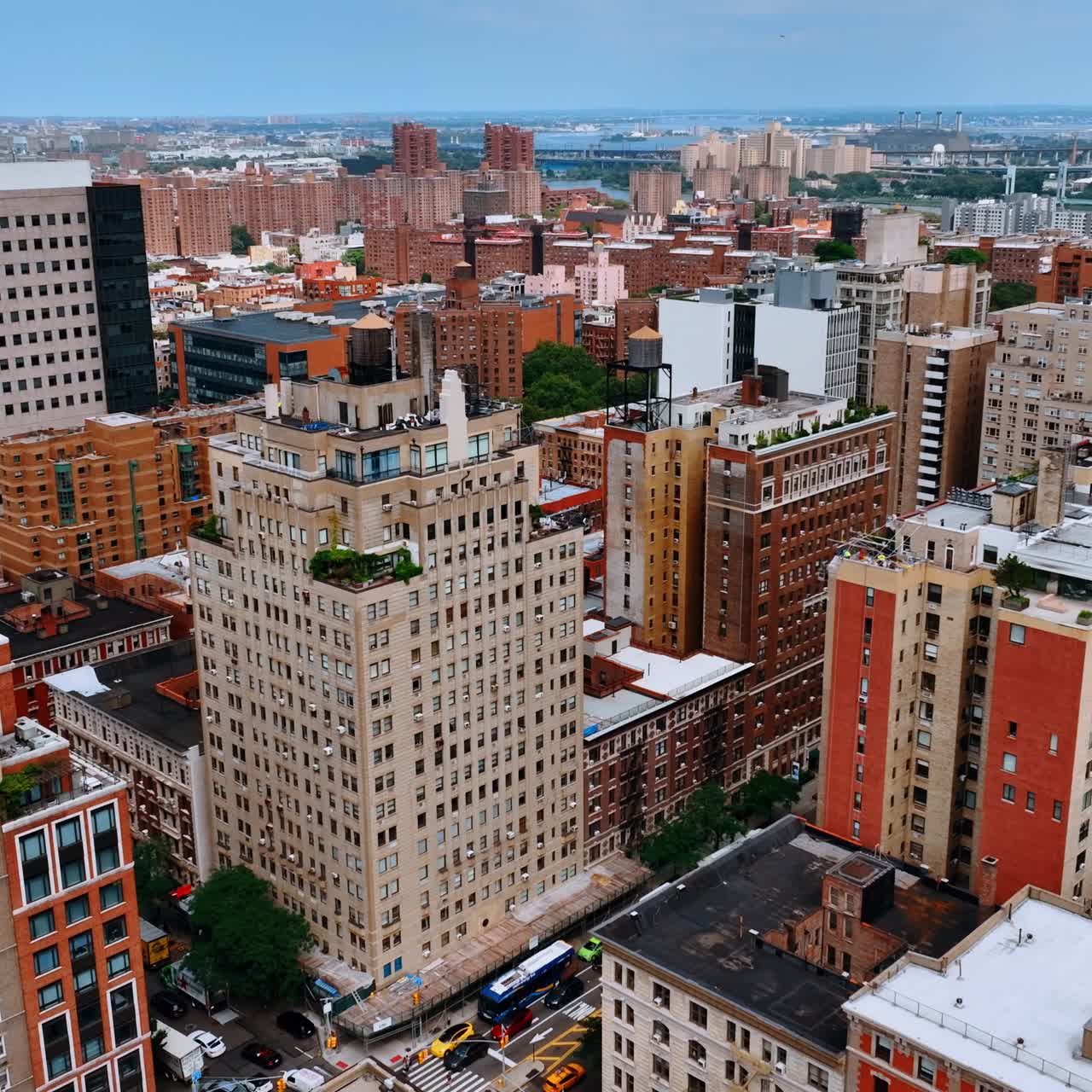Varied multistoried buildings of New York. Approaching large white house with garden on top. Aerial view