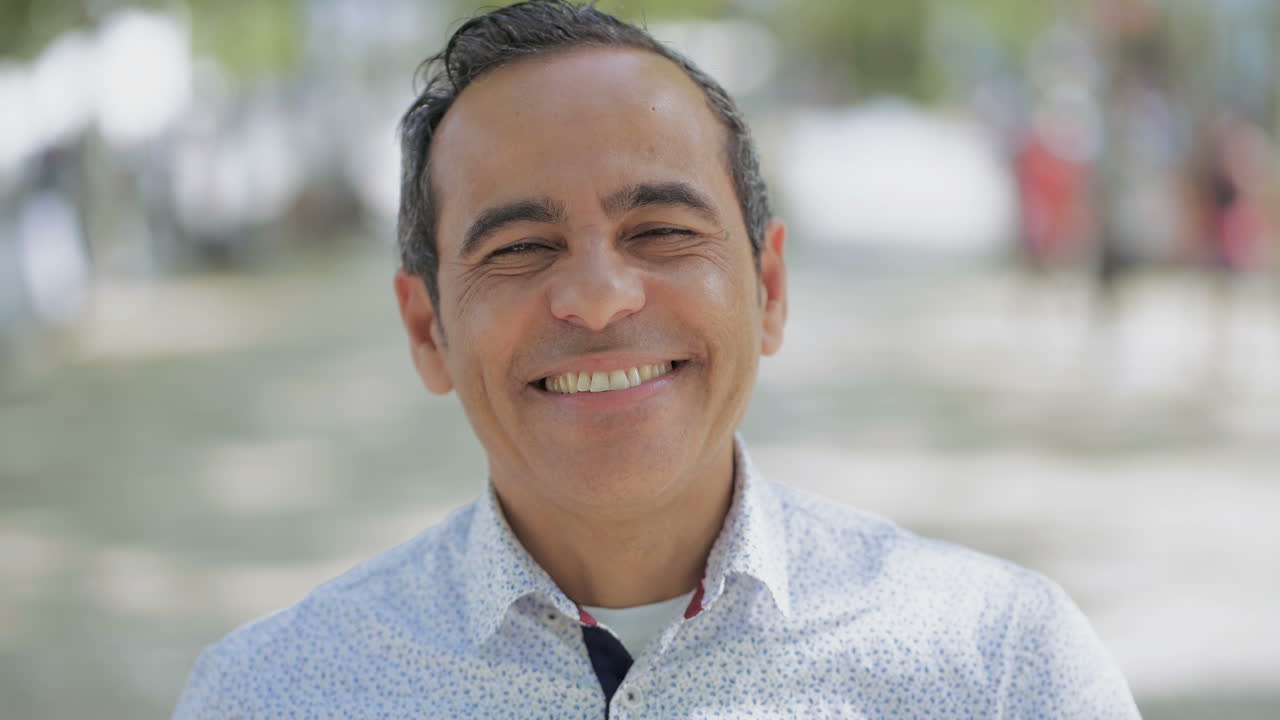 hombre maduro alegre sonriendo a la cámara al aire libre