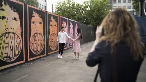 couple walking past a mural