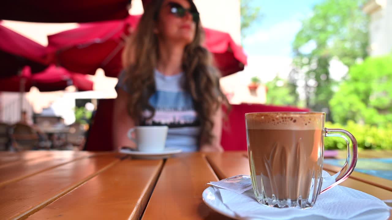 Woman drinking cup of coffee at a restaurant terrace