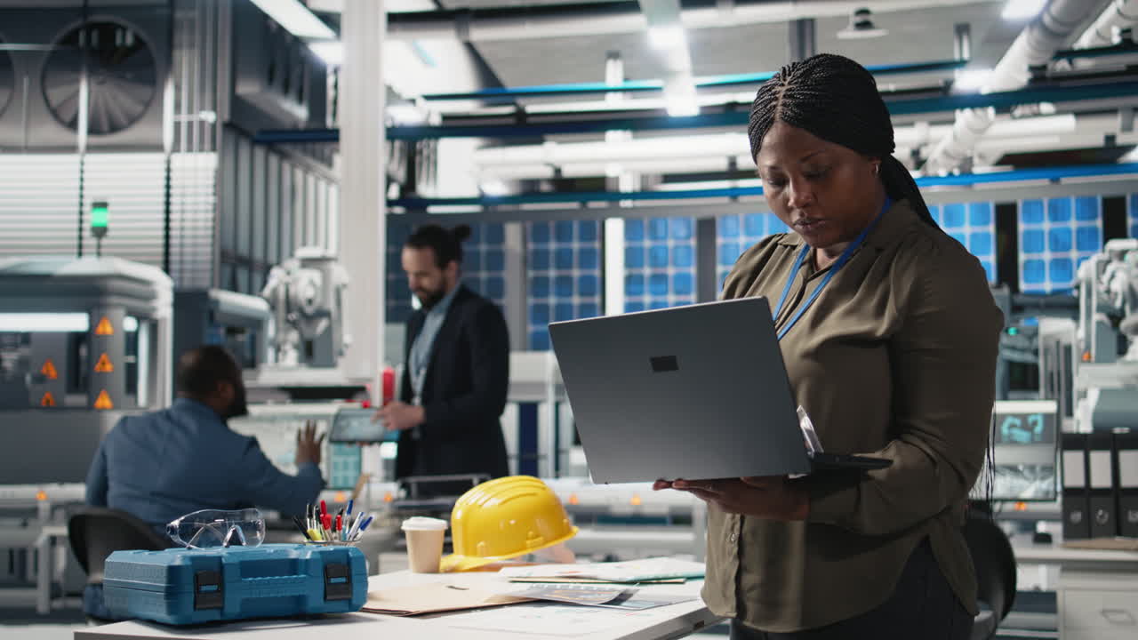 African American Engineer Inspecting Factory Production with Laptop