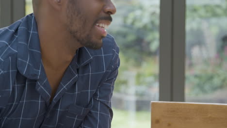 Middle-Aged-Man-Wearing-Pyjama-Top-Smiling-and-Laughing-During-Breakfast