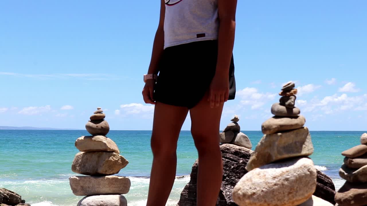 해변에 바위 탑을 쌓고 마지막 손질을 가하다