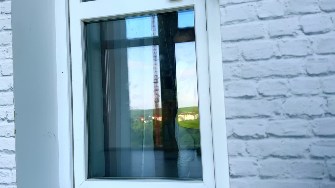 Cute toddler in yellow t-shirt sits on the threshold to a balcony. Lovely boy stands up, goes to the room and closes the door.