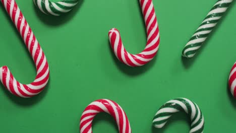 red and green striped candy canes on green background