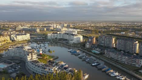 Gated-city-community-with-port-inside,-aerial-drone-shot-zoom-out