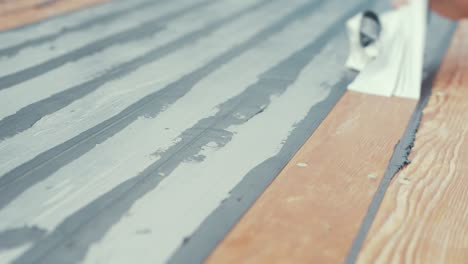 close up hands removing masking tape from boat roof douglas fir planking