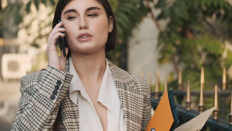 una mujer elegante haciendo una llamada de negocios al aire libre.