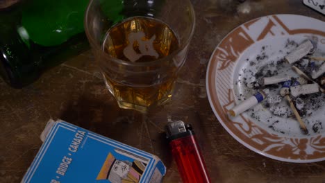 cards, gun and alcohol on a wooden table