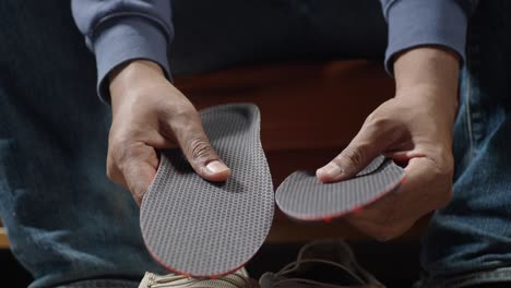 man holding shoe insoles