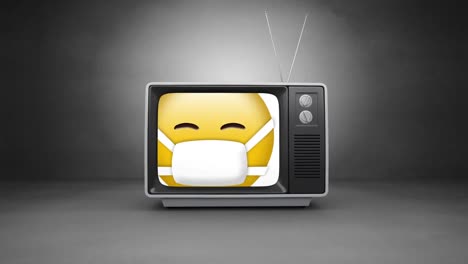 Face-wearing-mask-emoji-on-television-screen-against-grey-background
