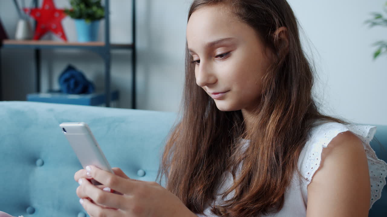 Teenager using smartphone on a sofa