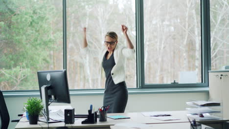 happy businesswoman dancing in office