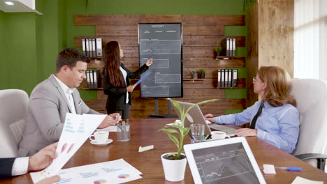 young femake having a presentation with financial charts on tv screen