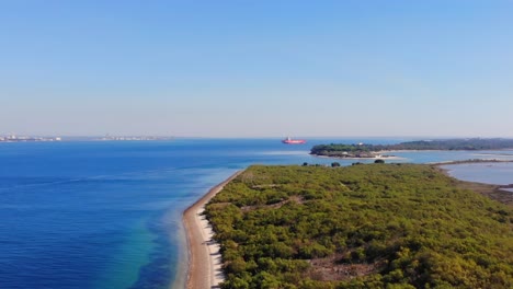 Drohnenaufnahme,-Die-Mit-Einem-Vor-Anker-Liegenden-Tankschiff-über-Land-Und-Wasser-Schwenkt