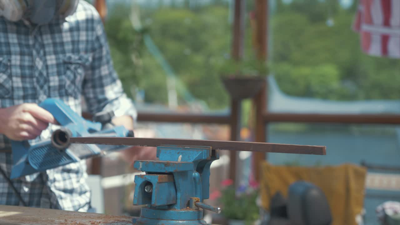 전기 대패 젊은 백인 남자와 티크 나무 트림 기획 깊이를 조정