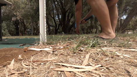 camper hammering a tent peg into the ground next to the caravans annex