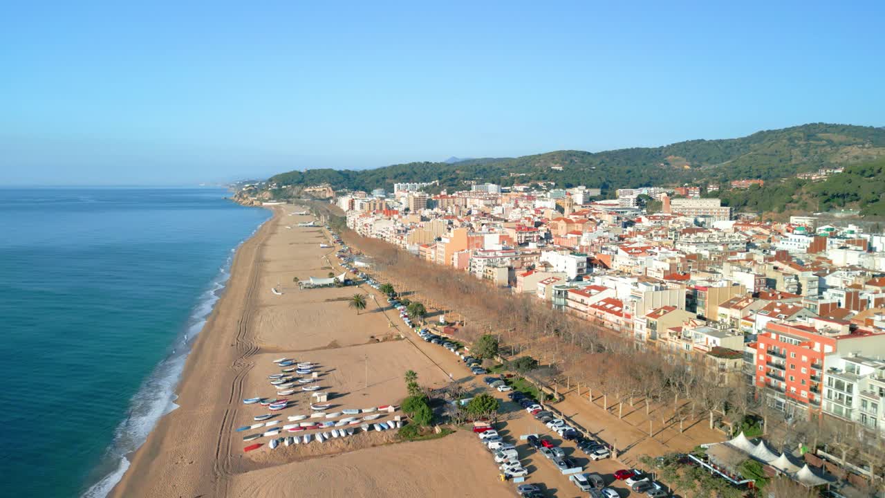 Aerial perspective capturing calella de mar's scenic coastline and urban landscape, showcasing vibrant buildings and sandy beaches along the mediterranean sea