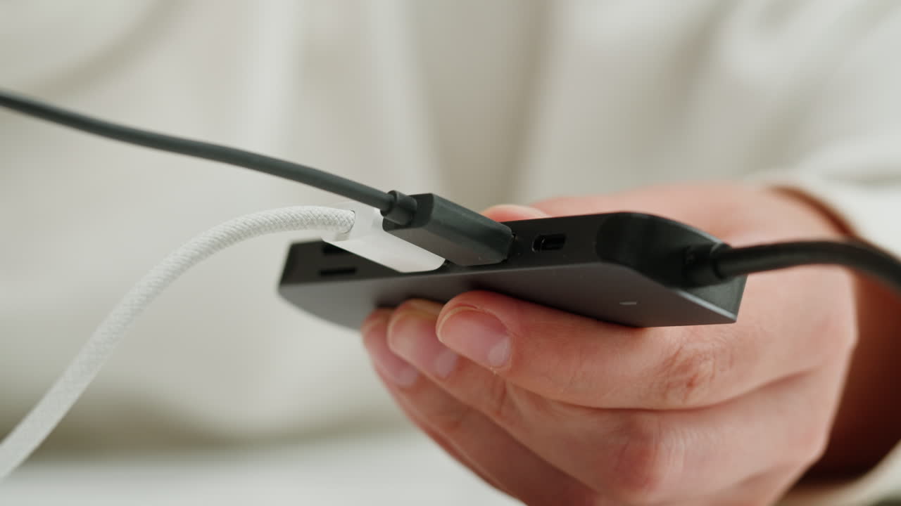 Using special adapter with many various of connector close-up. Adapter with phone, headphones, usb connectors.Tangled wires on table. Trying to untangle many messy cables.