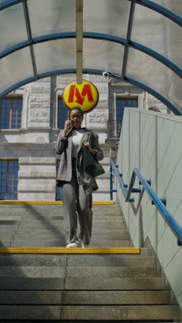 businesswoman using phone at metro station