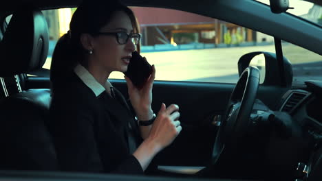 Attractive-caucasian-business-woman-in-a-parked-car-while-talking-on-the-phone,-and-then-drives-away