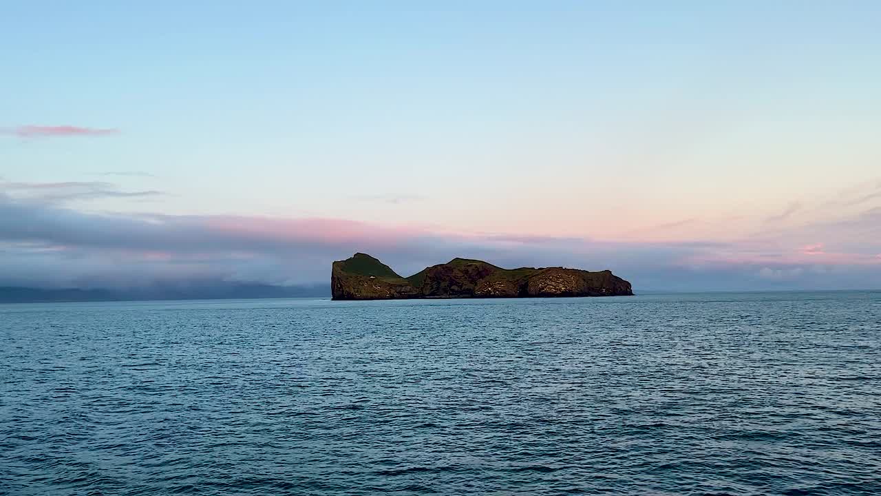 amplia vista de la lejana isla aislada de ellidaey con casa y océano abierto, vestmannaeyjar, islandia