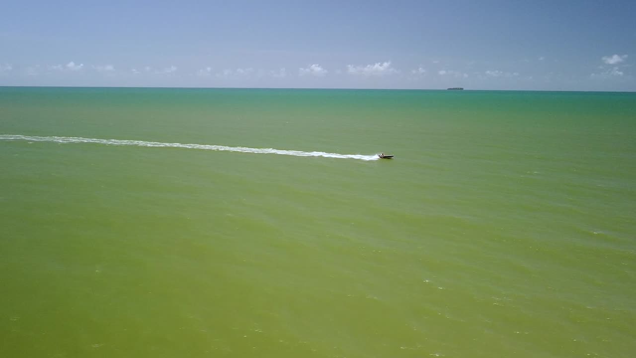 저 멀리 케언즈에 있는 트리니티 해변에서 바다를 건너는 과속보트의 조감도