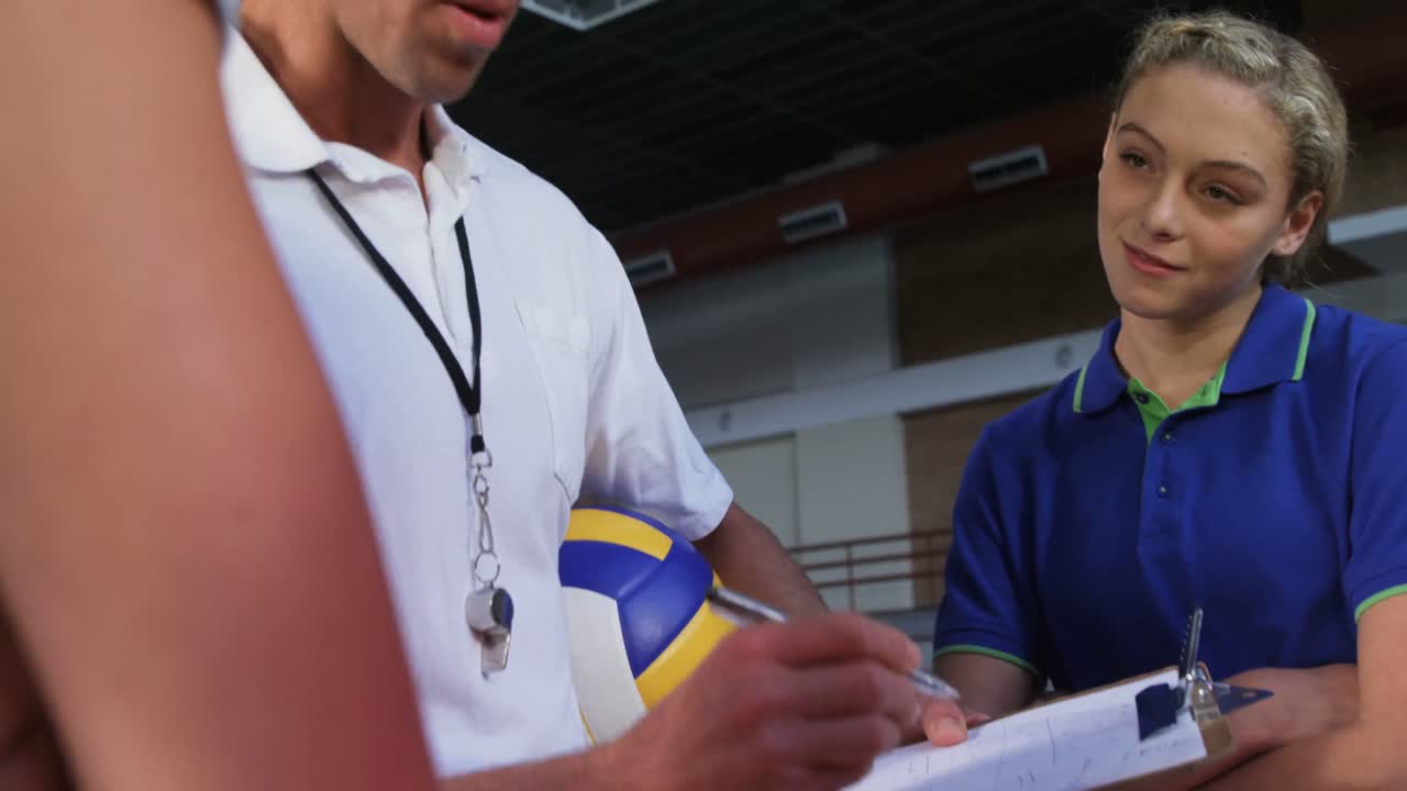 entrenador de voleibol ayudando a las jugadoras en el clipboard 4k