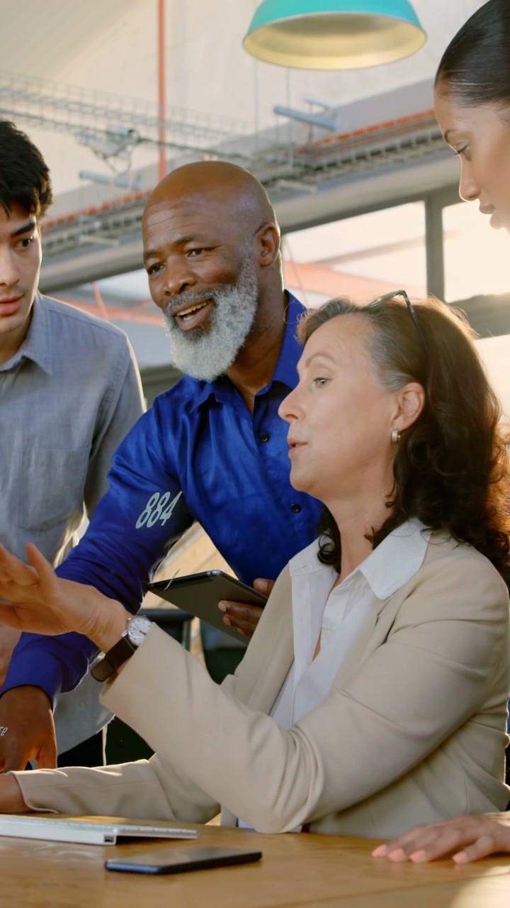 Vertical video: Lead pointing at screen sending business charts onto advisor's tablet for review