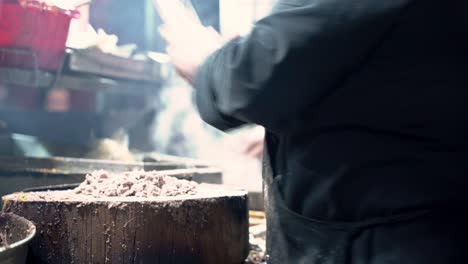 cook cutting meat with his shape knife