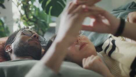 affectionate couple touching hands and cuddling on sofa