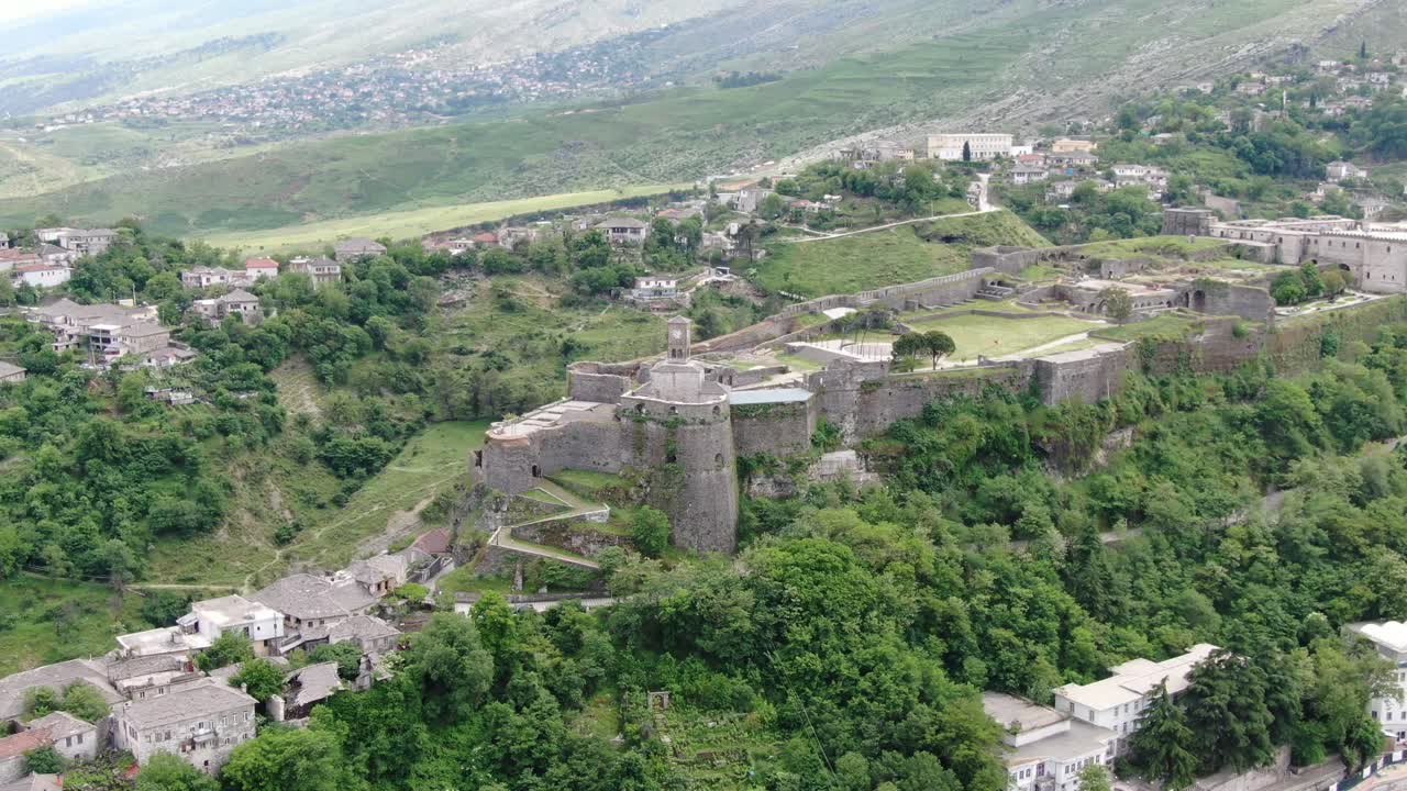 vista de avión no tripulado en albania volando en la ciudad de gjirokaster sobre un castillo medieval en una fortaleza de tierra alta que muestra las casas de techo marrón de ladrillo