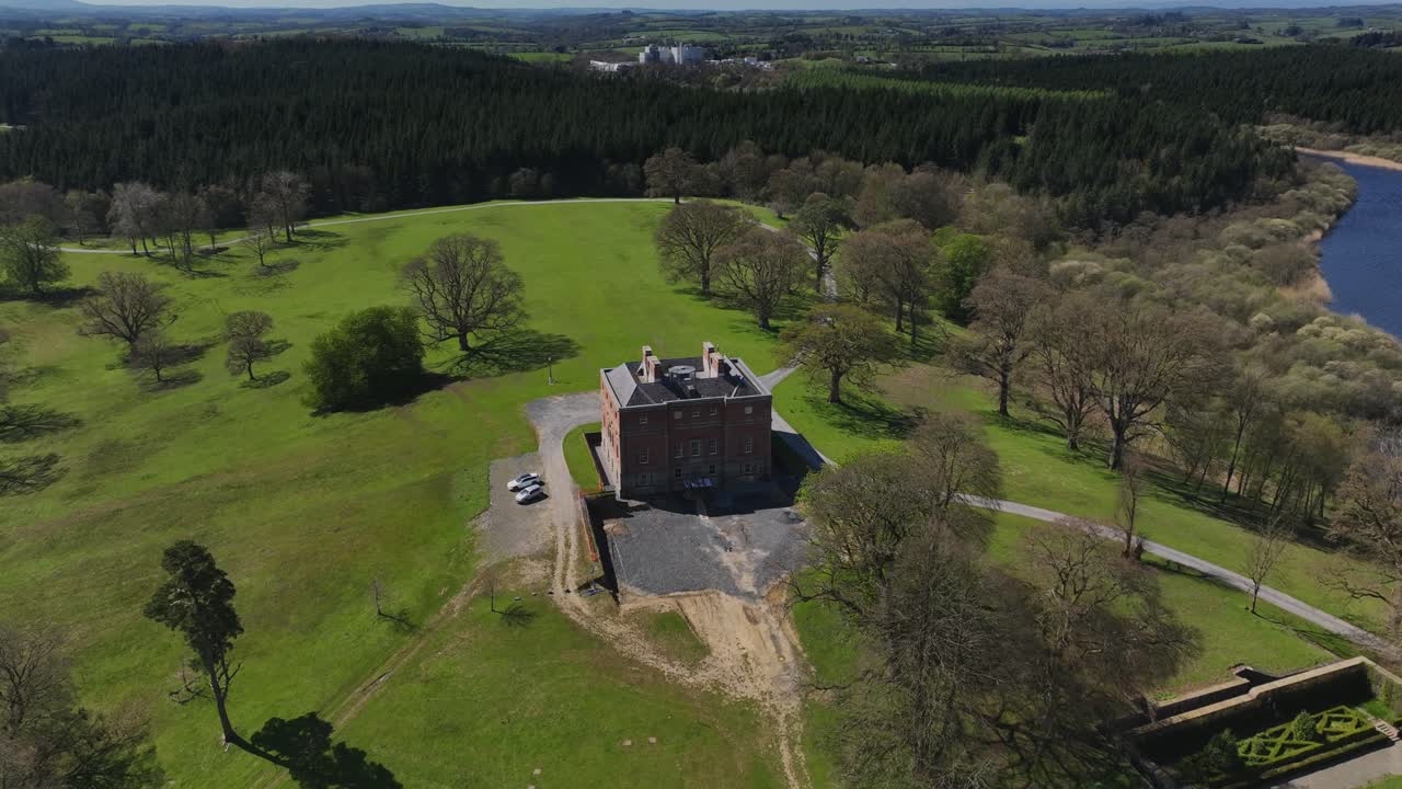Bellamont House, County Cavan, Ireland, April 2023. Drone orbiting counterclockwise around historic Georgian mansion, lake, green countryside and peaceful Irish landscape.