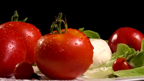 tomates y mozzarella en una hoja de lechuga giratoria, bucle