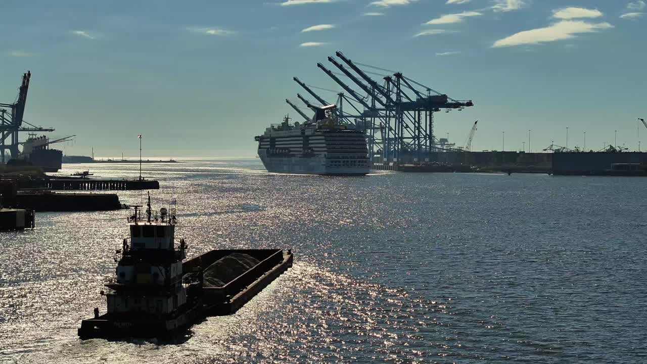 Crucero entrando en el puerto mientras una barcaza y un remolcador se dirigen hacia fuera
