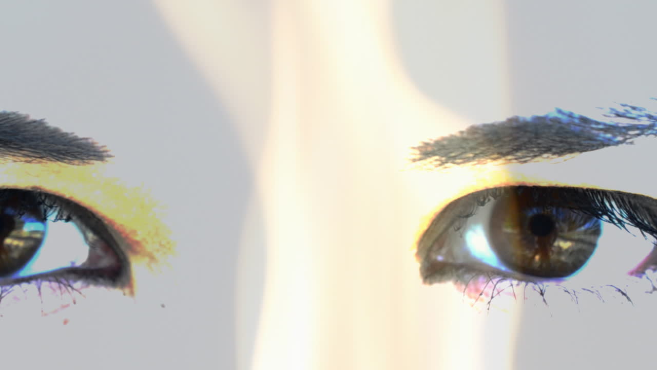 Girl's face. Female eyes against fire