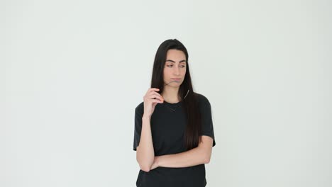 thoughtful young woman holding glasses against a white background