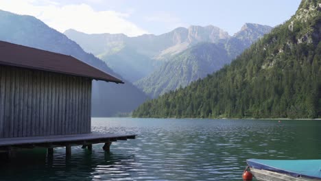 Casa-De-Pescadores-En-El-Lago-Con-Montañas-De-Fondo