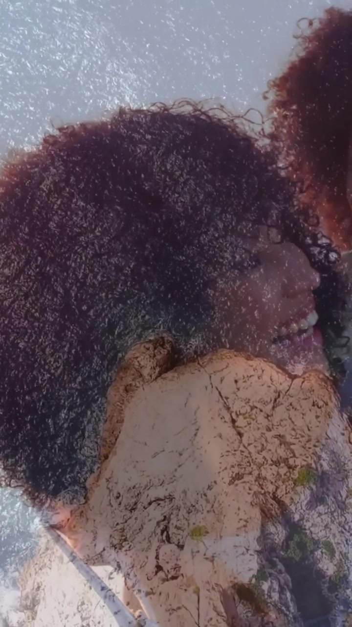 Video verticale: Mamma e bambino che viaggiano, che si appoggiano mentre una sovrapposizione del mare sfuma nei loro volti, creando un legame, cintura di sicurezza