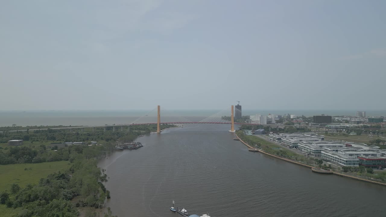 Splendida vista aerea con drone della città di Bintulu, Sarawak, con fiume, barca e piccola nave mercantile, accanto al mercato umido e, sullo sfondo, il nuovo ponte di Bintulu e anche una piccola pista di atterraggio inutilizzata.