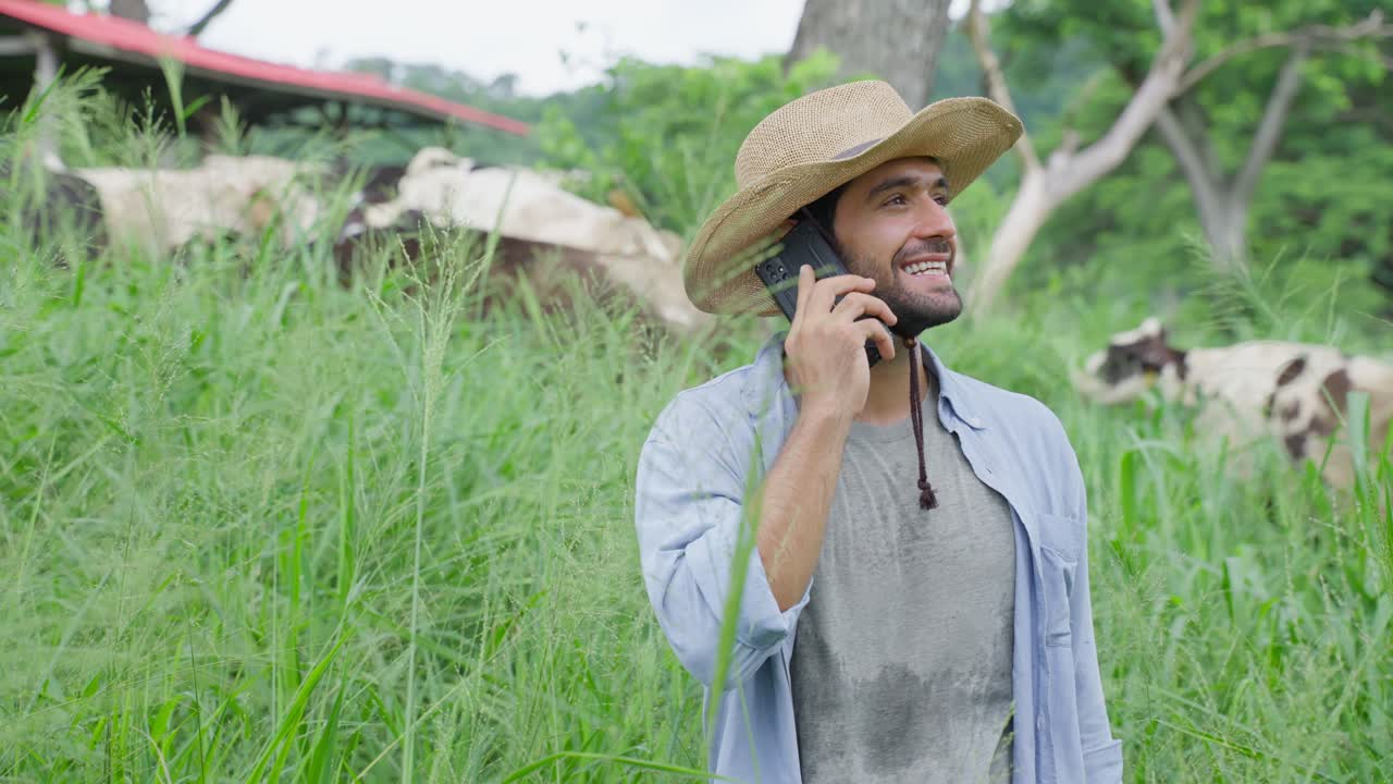 Contadino che parla al telefono in fattoria