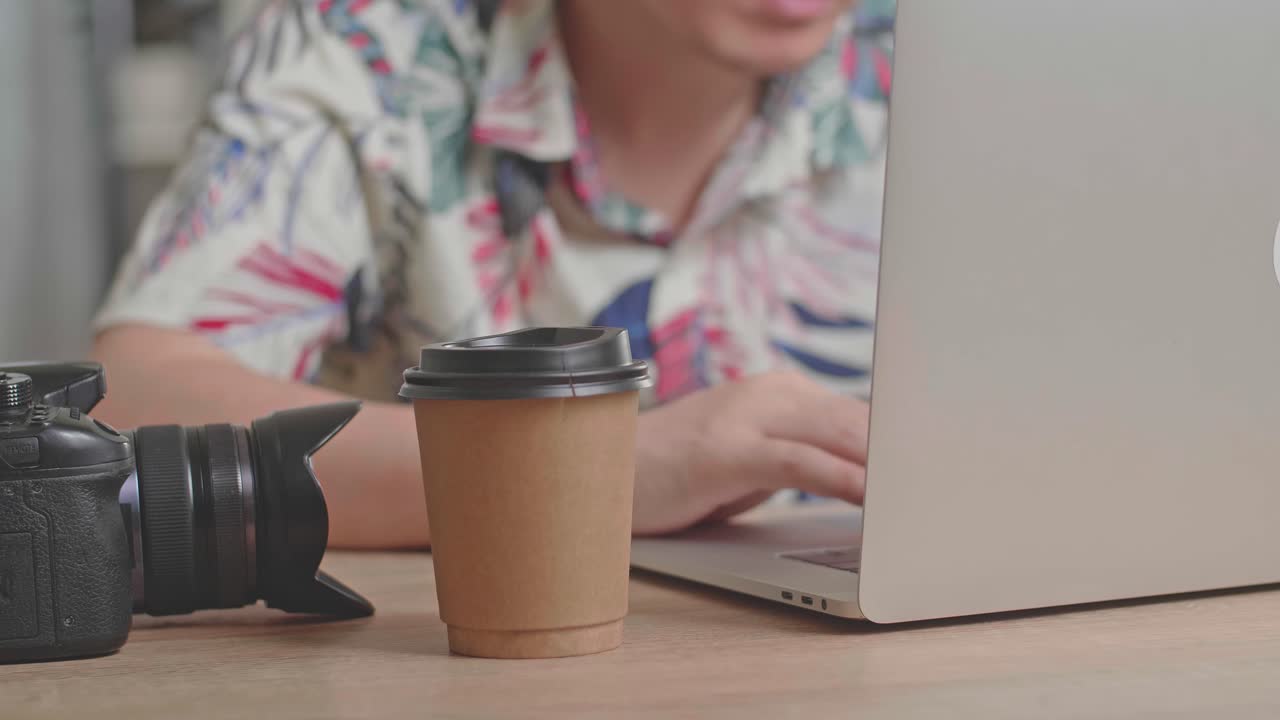 Photographer working at home with laptop and camera