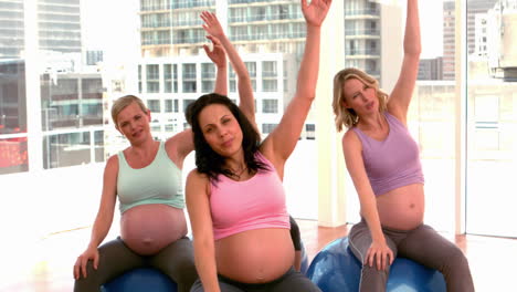 pregnant women doing yoga in fitness studio